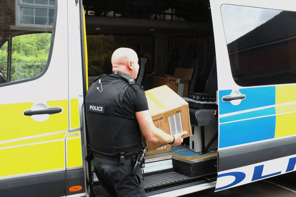 Police officer pictured carrying a box of illicit streaming devices