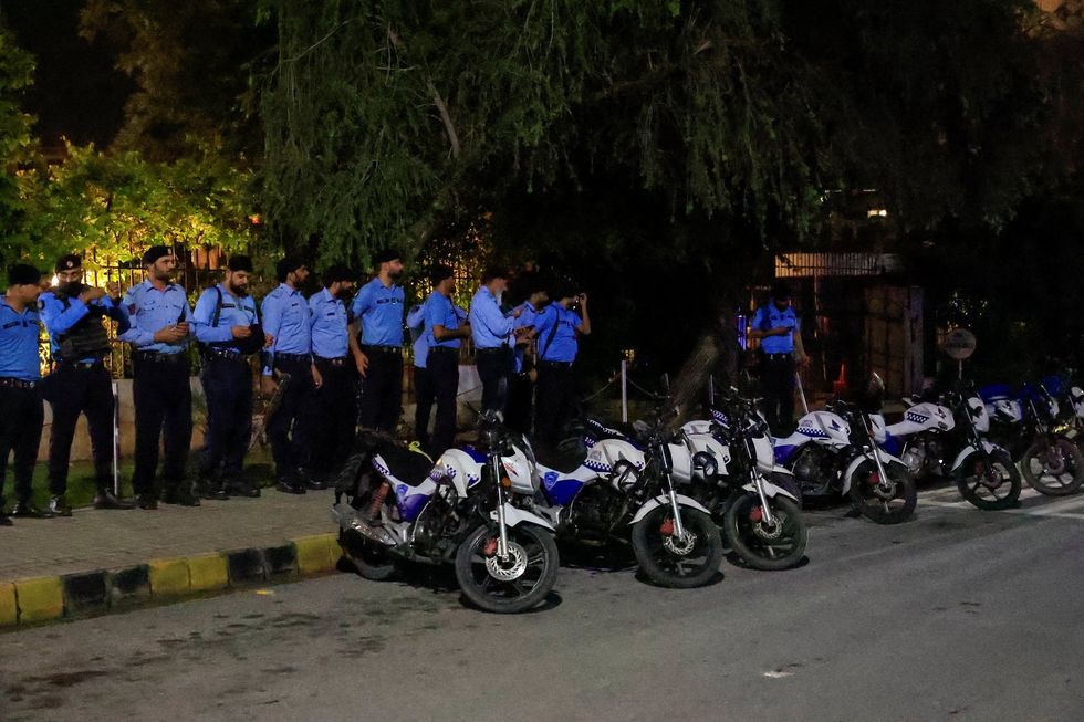 Police officers stand guard outside Shifa International Hospital