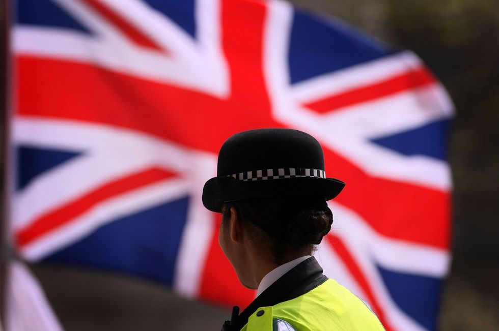 Policewoman stands in front of Union Jack