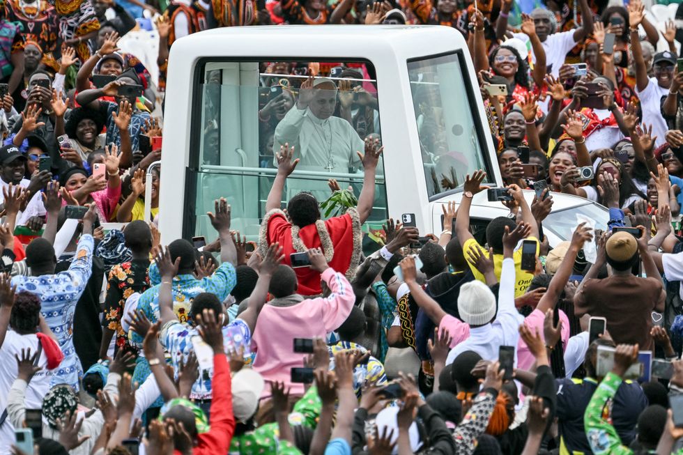 Pope Leo XIV rides in the Popemobile as Cameroonians surround the vehicle