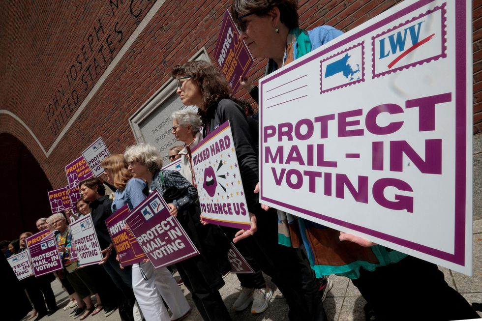 Protesters advocating for mail-in voting to be protected outside a Boston court