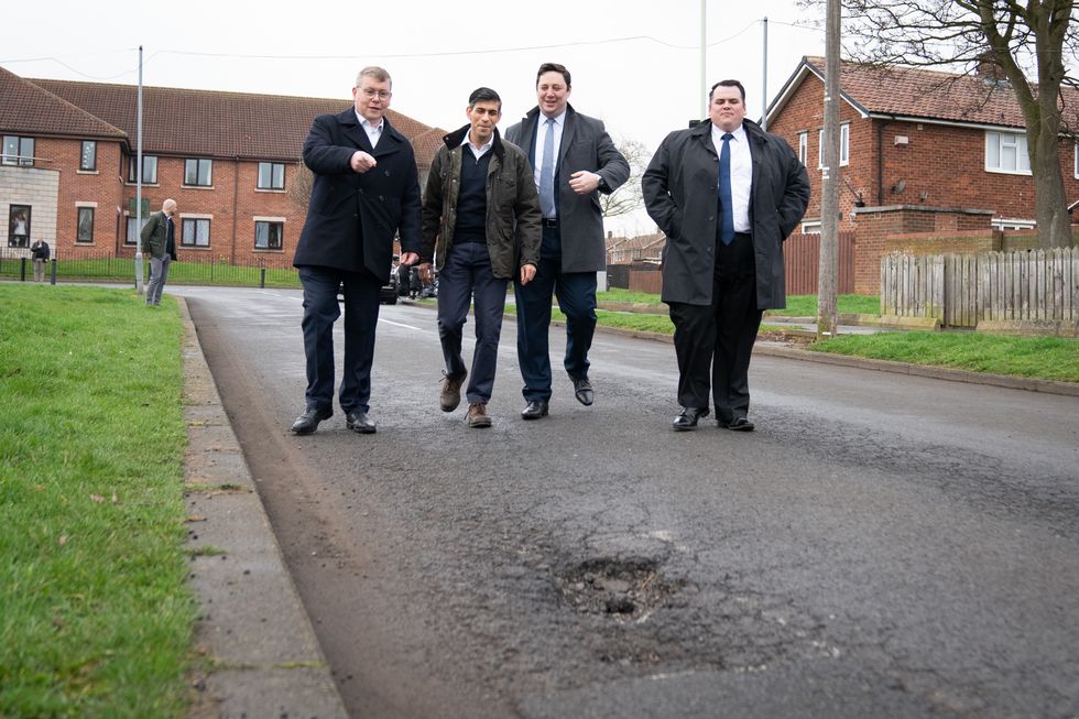 Rishi Sunak looking at a pothole