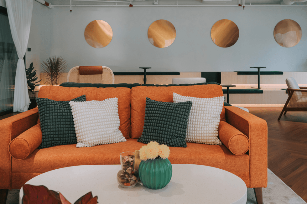Room decorated with light blue walls and an orange couch