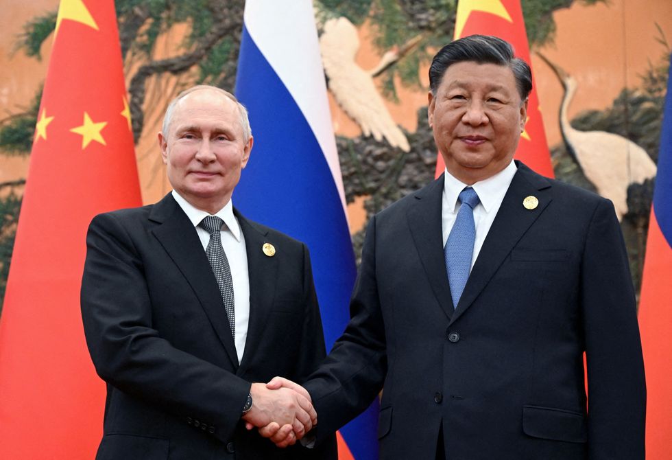 Russian President Vladimir Putin shakes hands with Chinese President Xi Jinping during a meeting at the Belt and Road Forum in Beijing