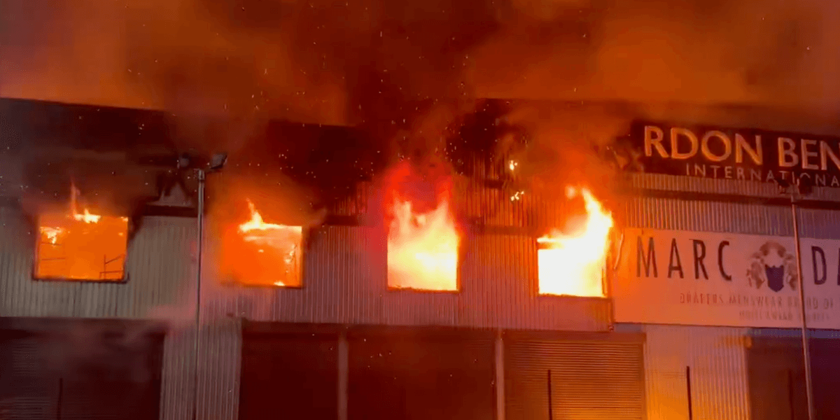 Huge fire rips through building and busy roads close down during rush hour as emergency services rush to deal with raging inferno