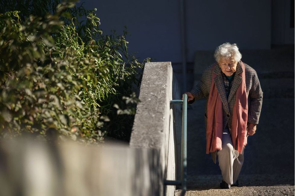 SENIOR FEMALE CLIMBING STAIRS