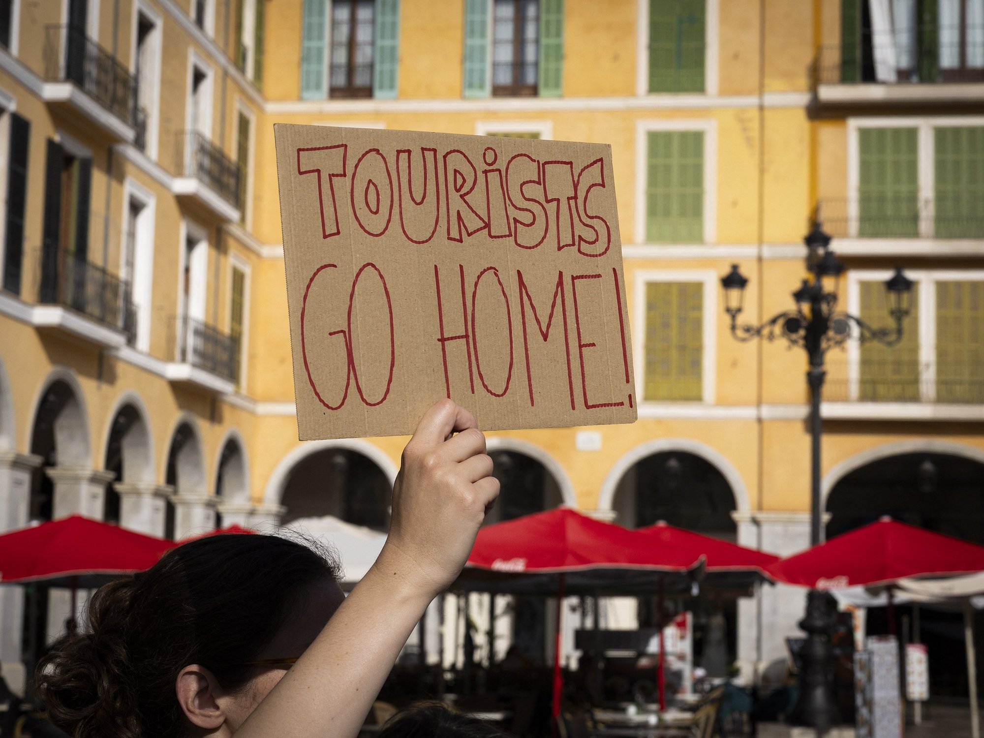 Sign which reads 'tourists go home' from previous