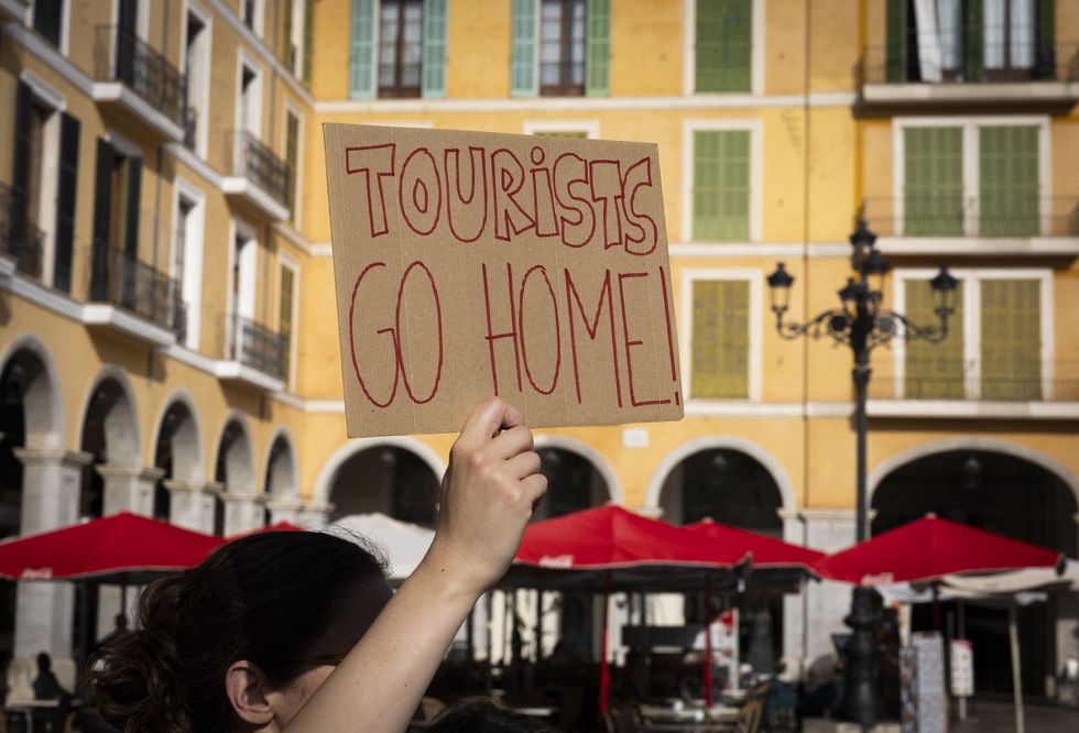 Sign which reads 'tourists go home'