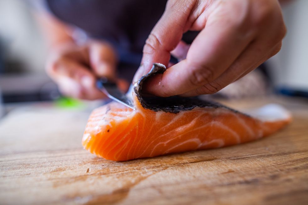 Skinning salmon on a chopping board