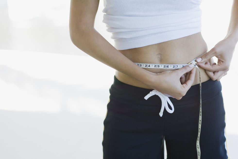Slim woman measuring waist