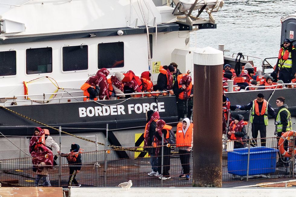 Small boat migrants stepping off Border Force boat