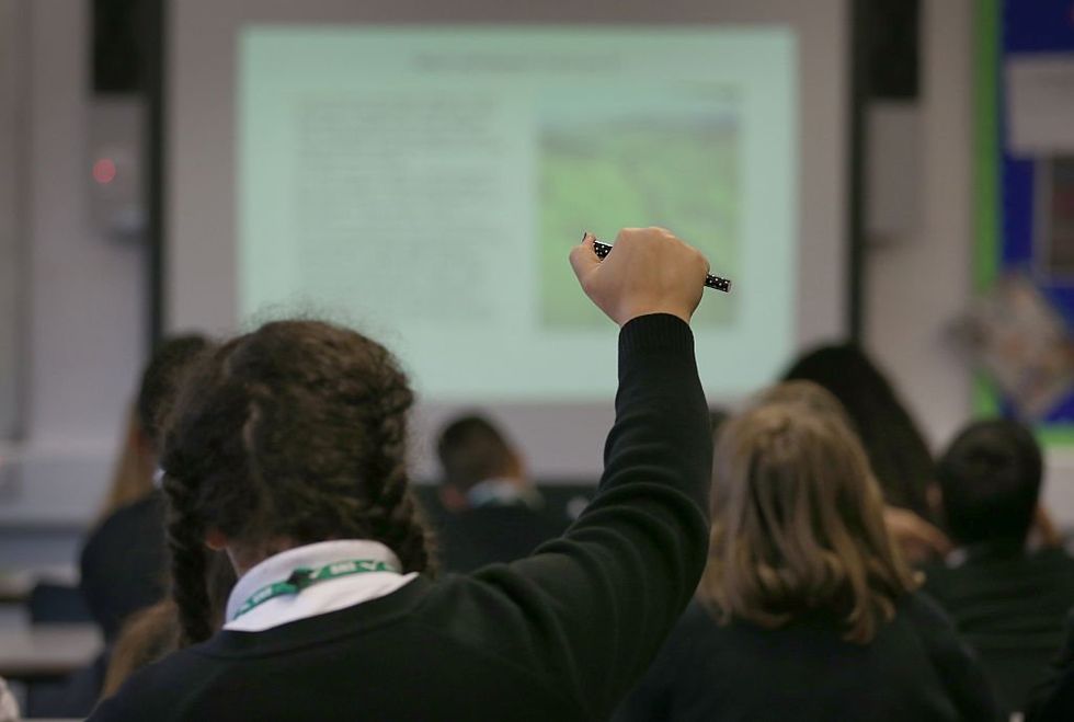 Student raising hand in a classroom