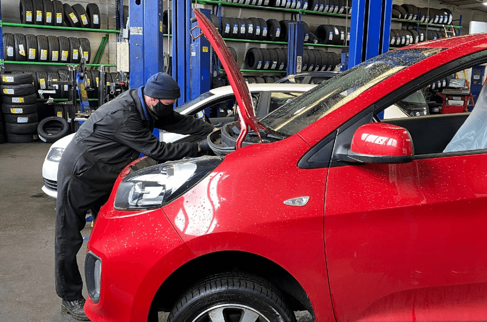 Technician performing an MOT test on a car