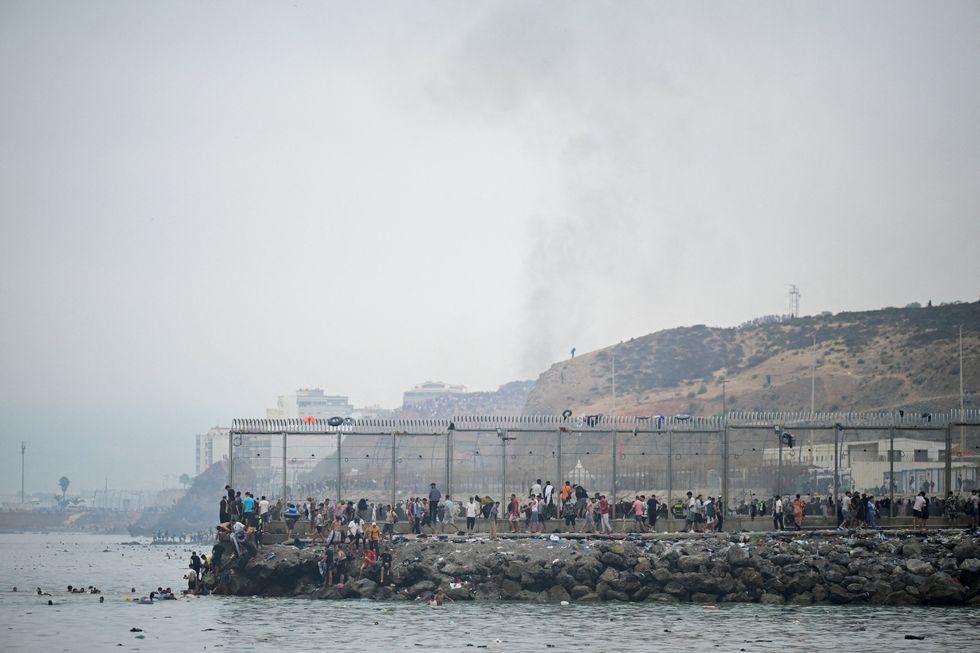 Thousands of migrants swam over to Ceuta's border yesterday, scaling the fence and entering Spanish territory