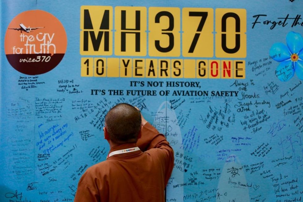 \u200bFamilies write on the memorial wall for victims of MH370