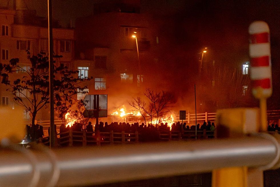 \u200bIranians gather while blocking a street during a protest in Tehran,