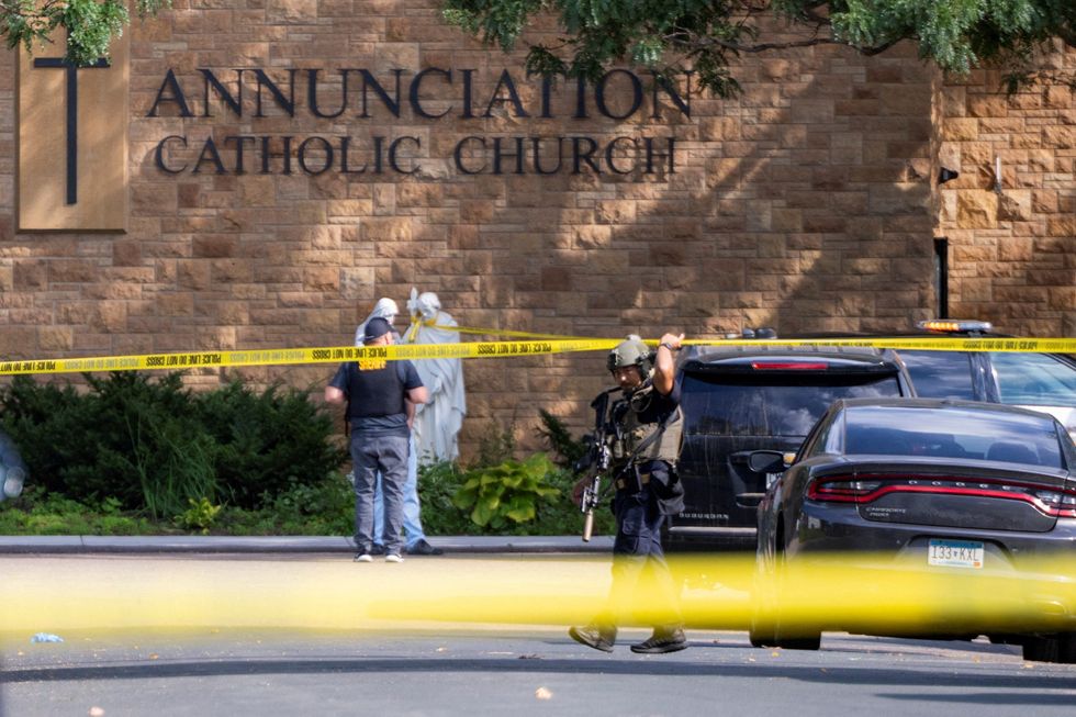 \u200bLaw enforcement officers set up barriers after a shooting at Annunciation Church