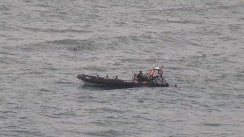 \u200bMigrants approaching a police boat in Cueta