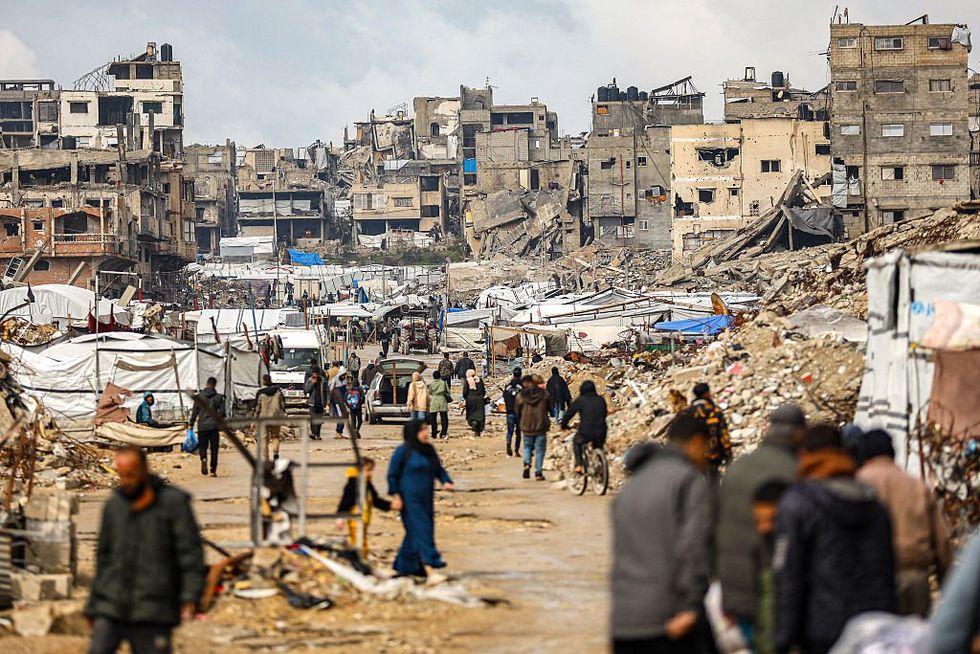 \u200bPalestinians wander through the rubble in Gaza