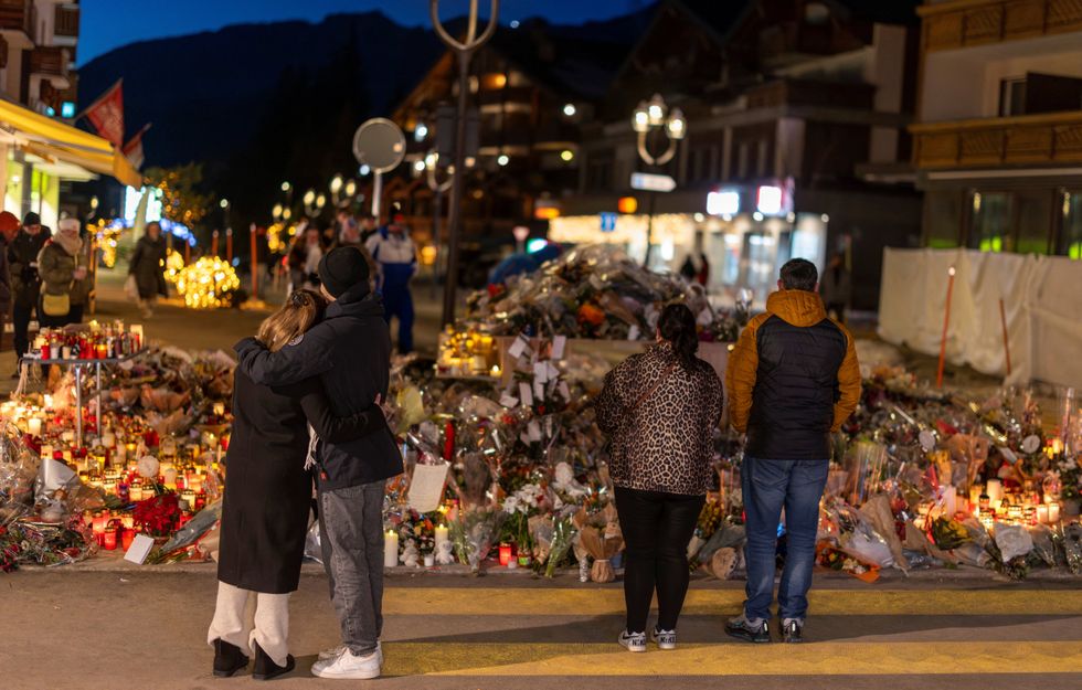 \u200bPeople visit a makeshift memorial outside the 'Le Constellation' bar