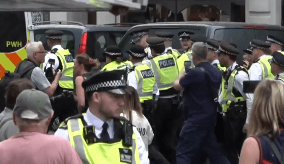 \u200bPolice usher away a protester