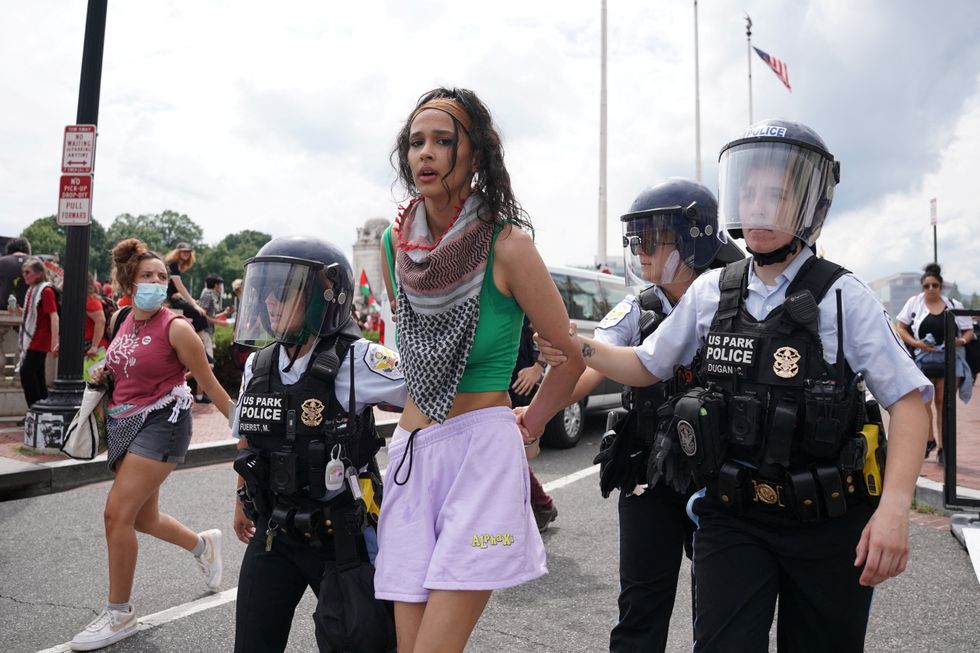 \u200bUS Park Police officers escort away a handcuffed demonstrator at a pro-Palestinian protest