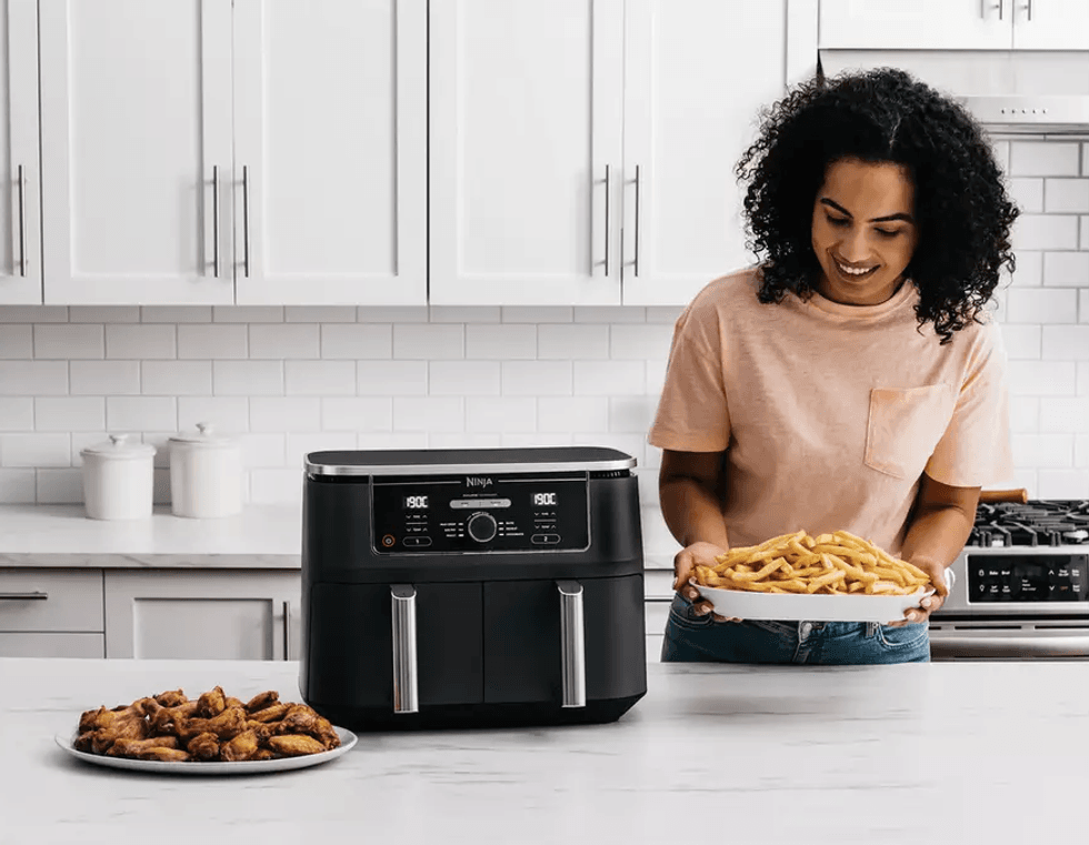 Wings and chips on plates after being prepared in the Ninja Foodi Max Dual Zone air fryer