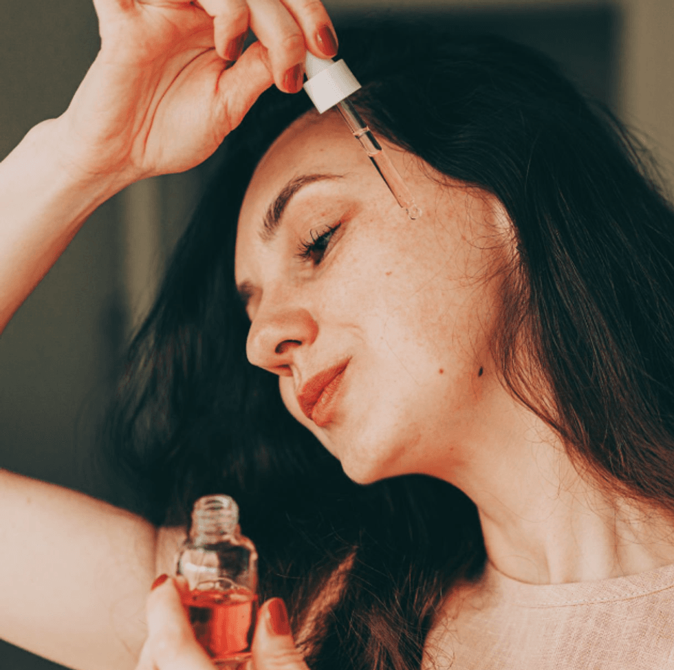 woman applying essence to face