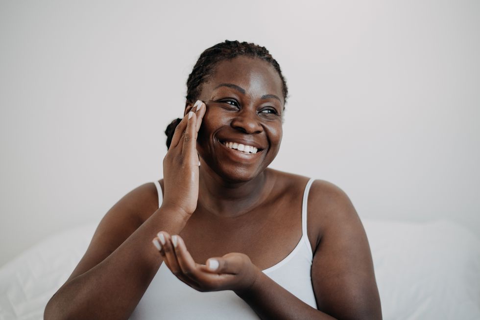 Woman applying moisturiser to her face