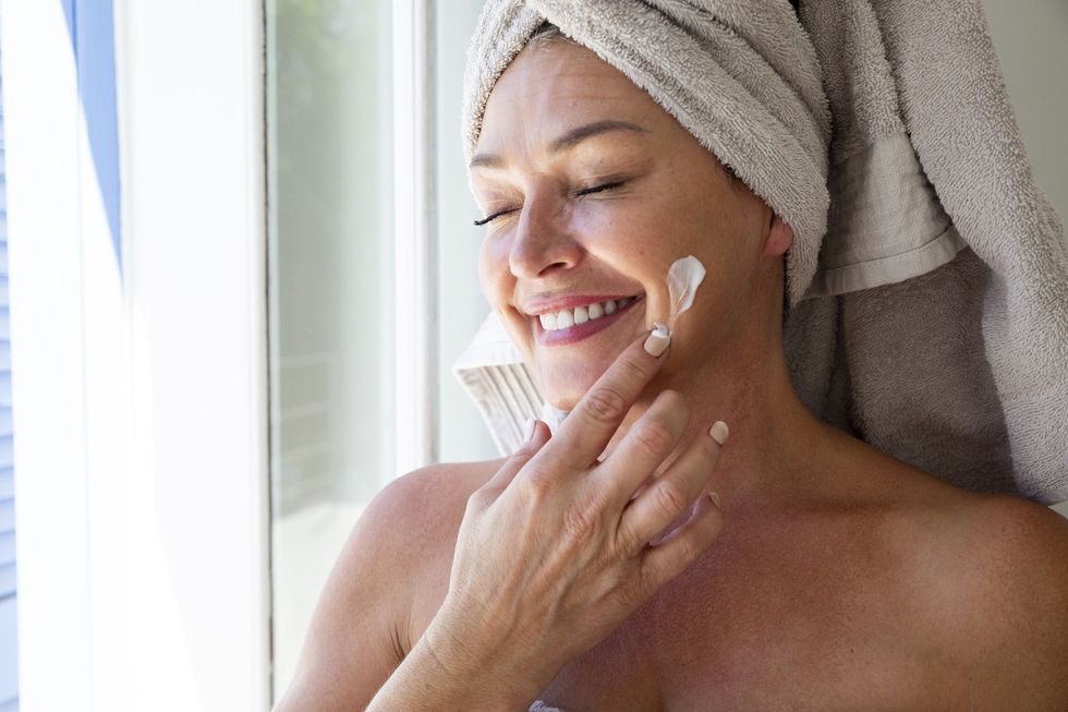 Woman applying moisturiser