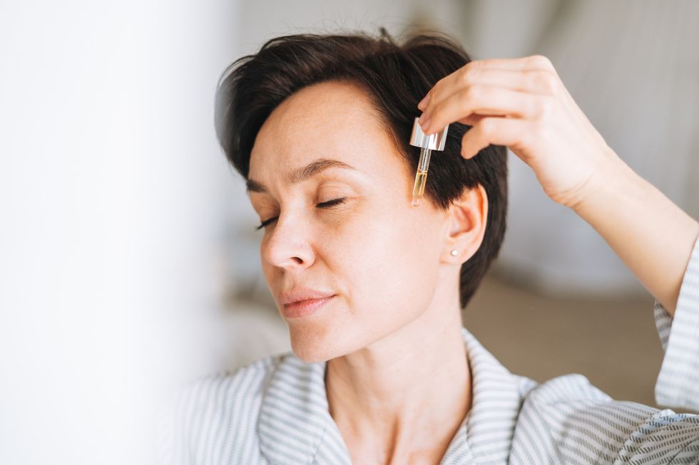 Woman applying skin care serum