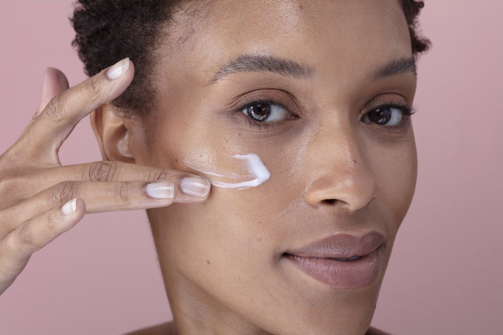 Woman applying sunscreen to her face