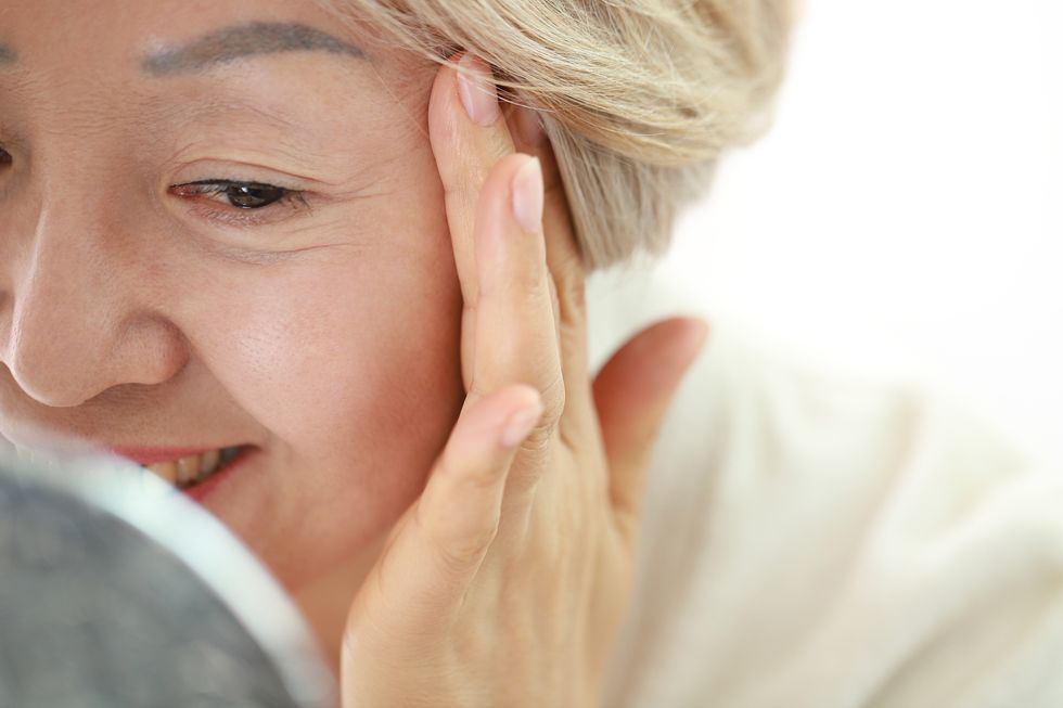 woman checking lines around eyes 