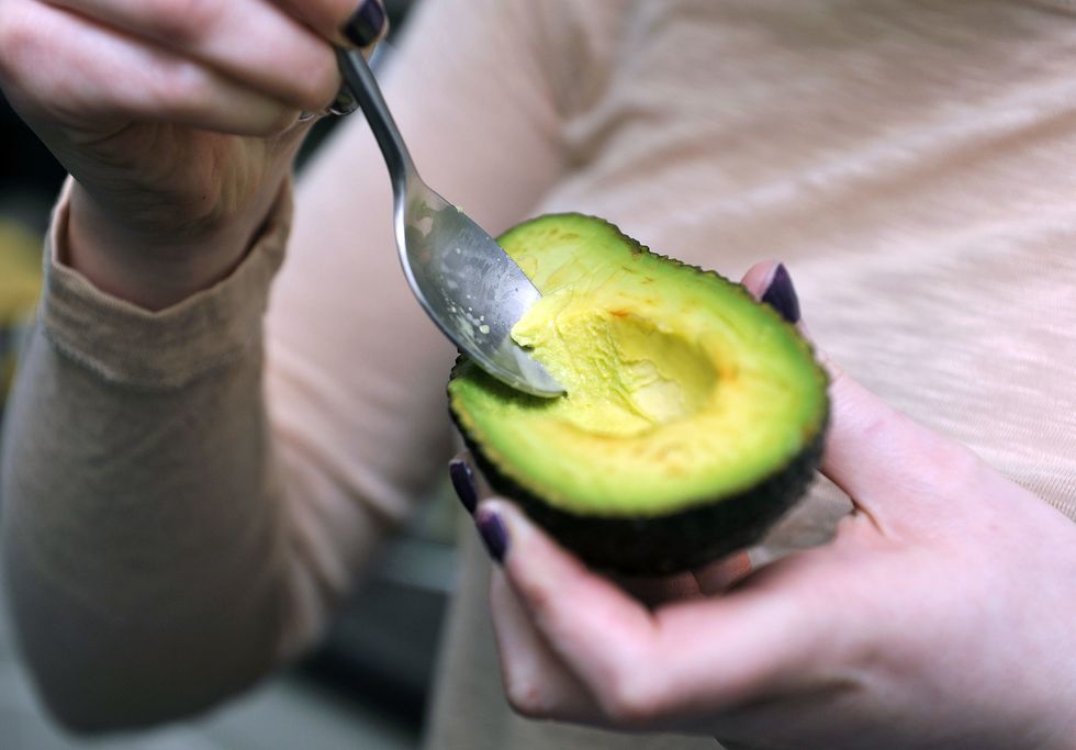 Woman eating avocado