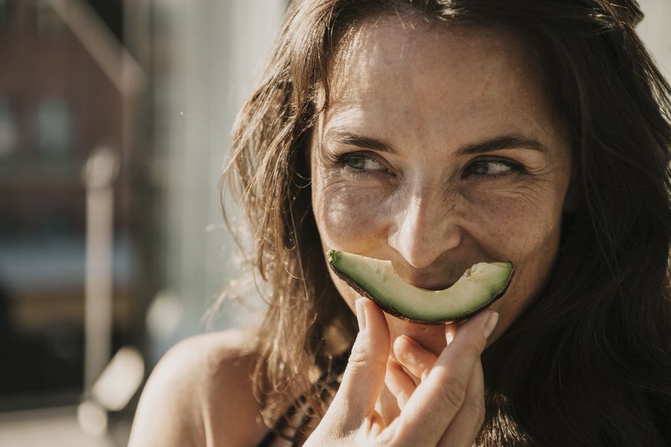 Woman eating avocado