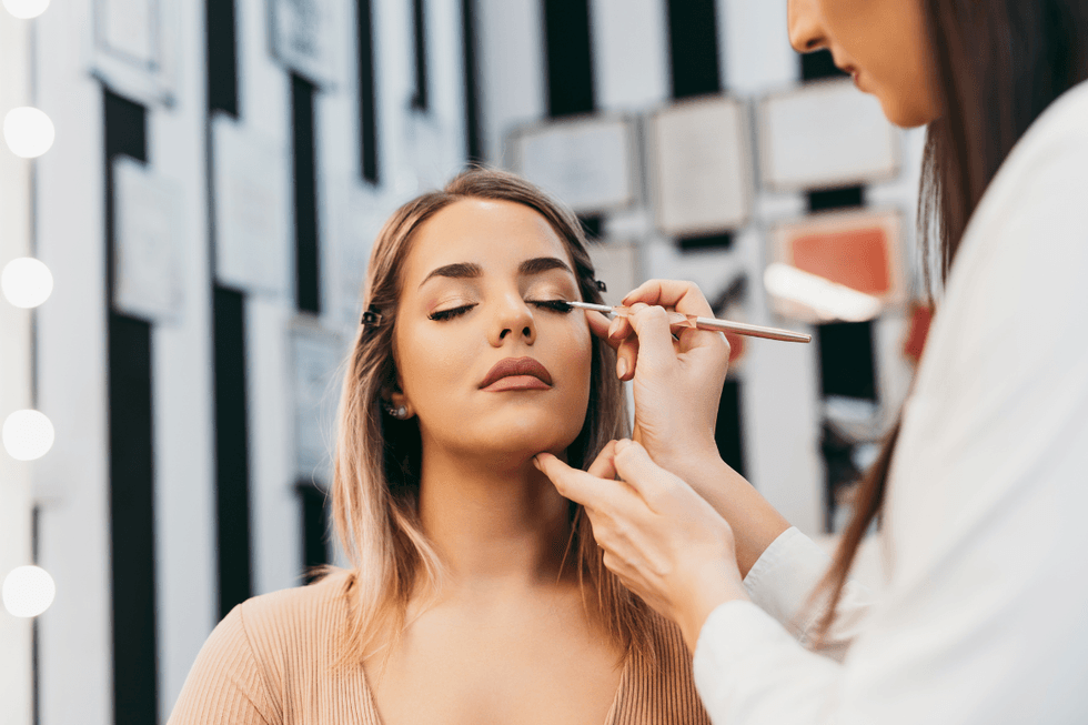 Woman getting her makeup done by another artist
