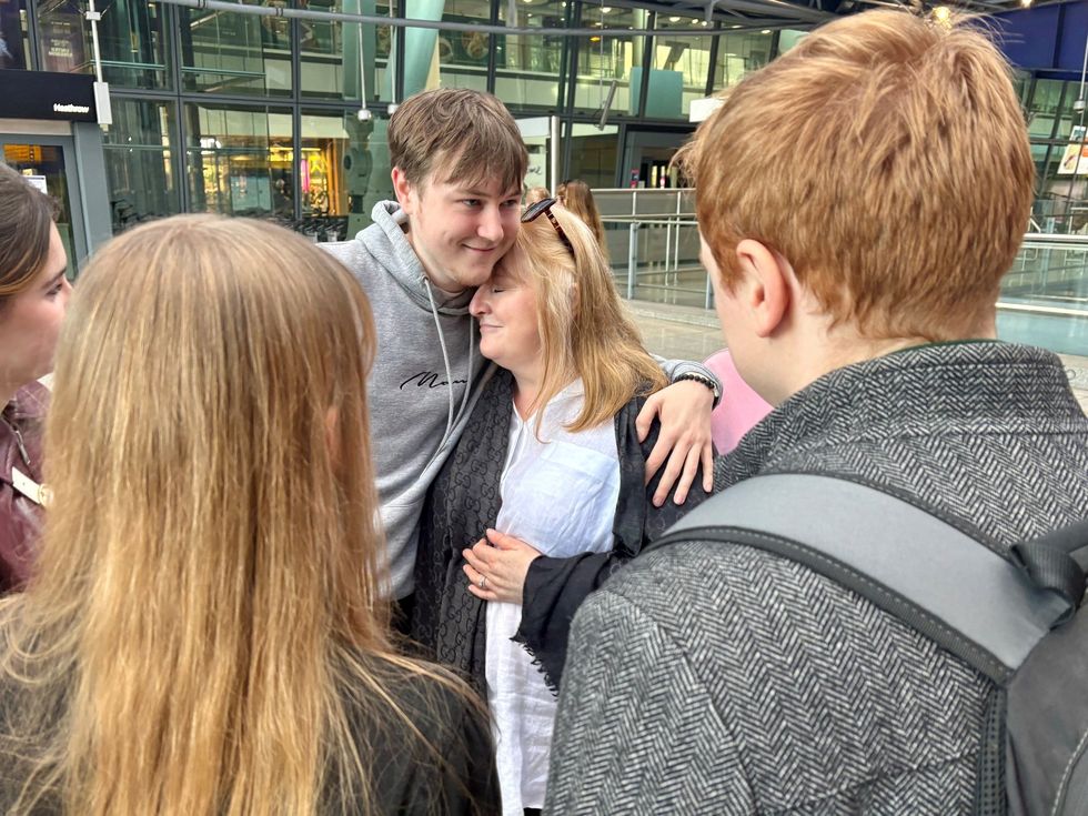 Woman greeted by son after evacuation flight