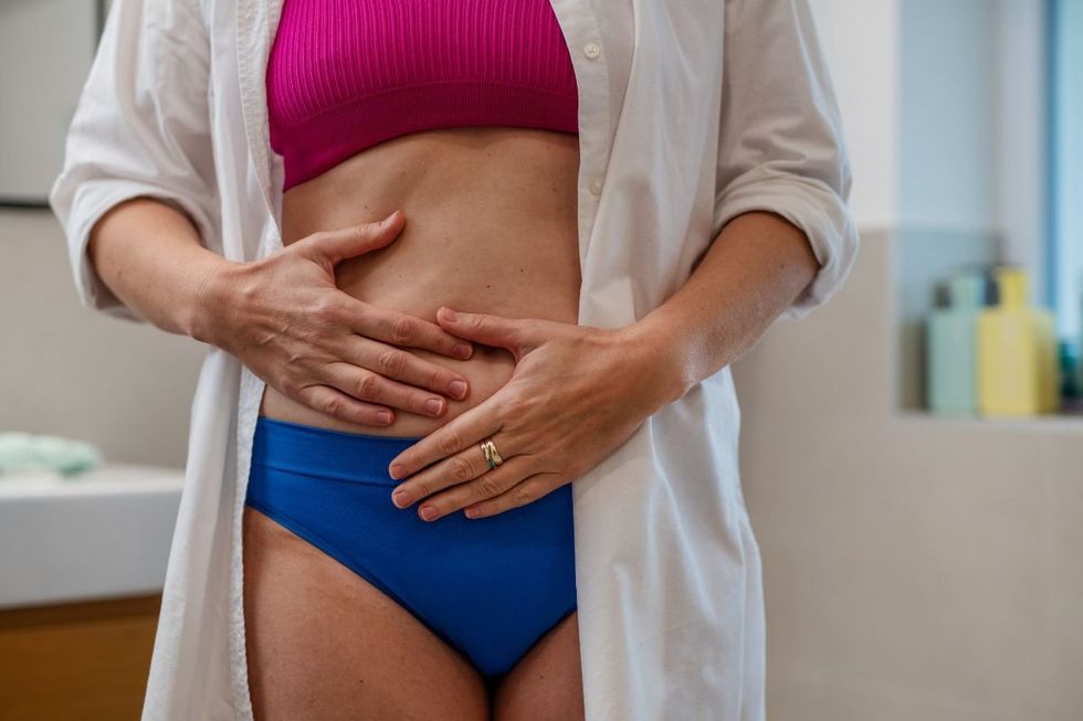 WOMAN HOLDING STOMACH