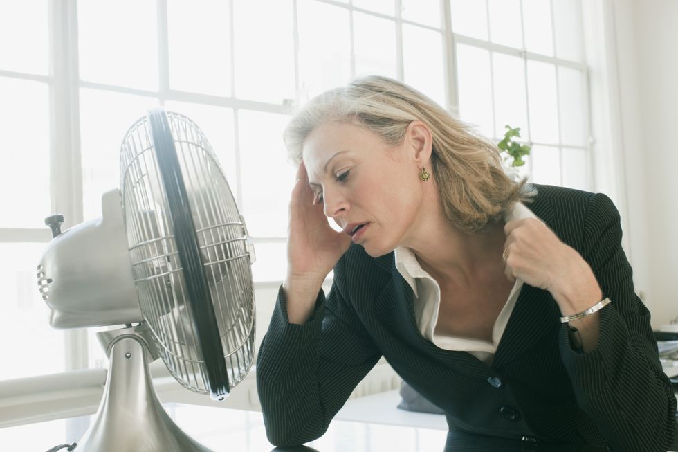 Woman in office sat by fan