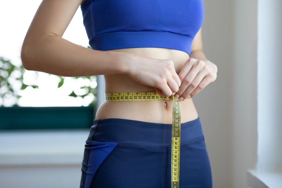 Woman measuring waist size