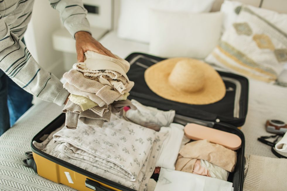 Woman packing clothes in suitcase