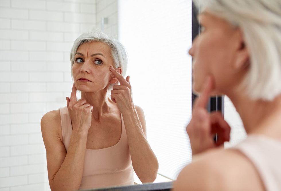 Woman touching and examining her face