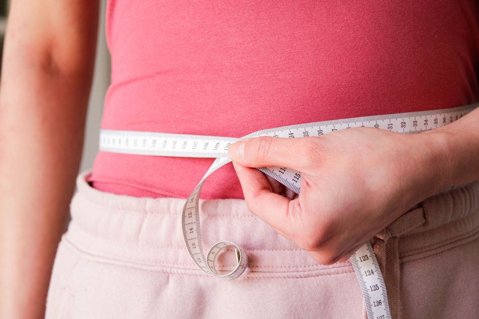 Woman using a tape measure around her waist