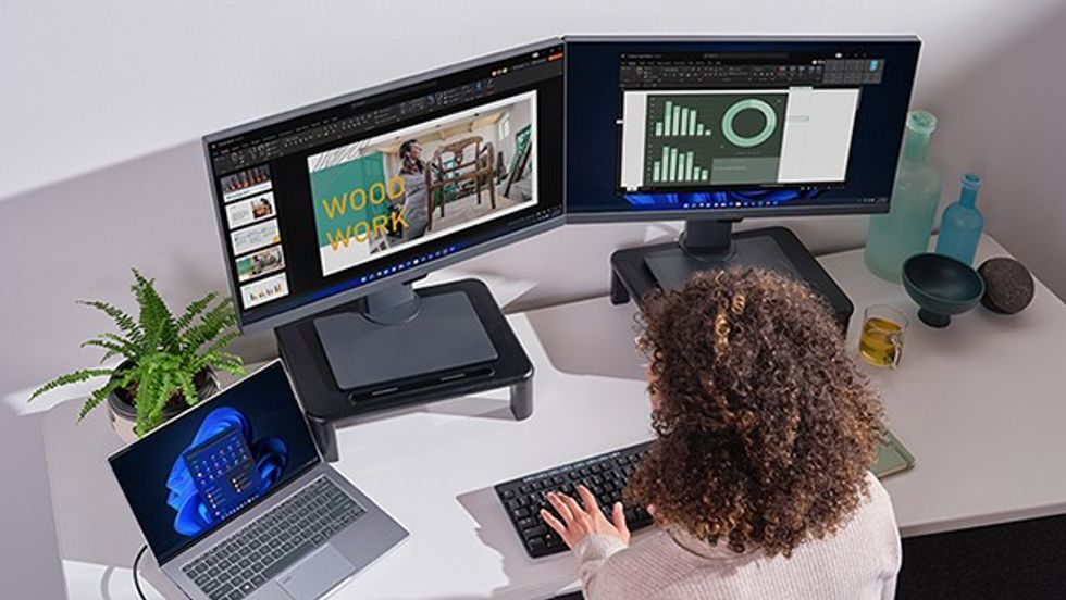 Woman using Windows 11 across three different screens